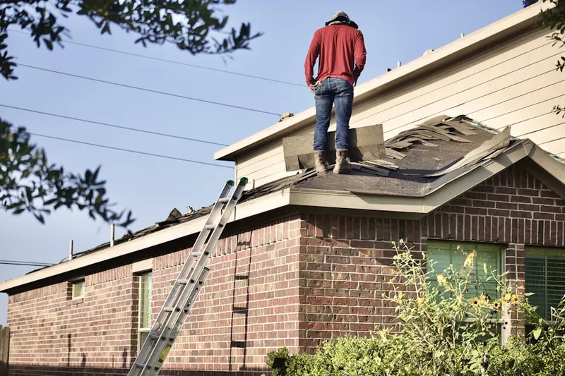 Professional roofer working on a residential roof in Evergreen